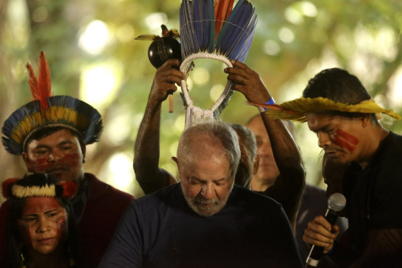 Brazil’s now president-elect Luis Inacio Lula da Silva receives a headdress from Assurini indigenous people in Belem, Para, Brazil, in September. He has promised to reverse Bolsonaro’s forest policies.
