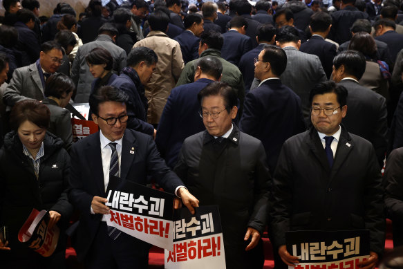 Lee Jae-myung (second from right), the leader of South Korea’s main opposition party, and lawmakers after the vote to impeach South Korea’s president failed.