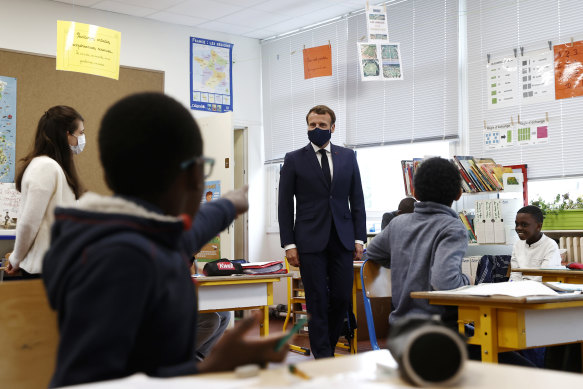 "Who's that?": French President Emmanuel Macron, in a mask, told the students people may have to stay near their homes during the summer holidays.