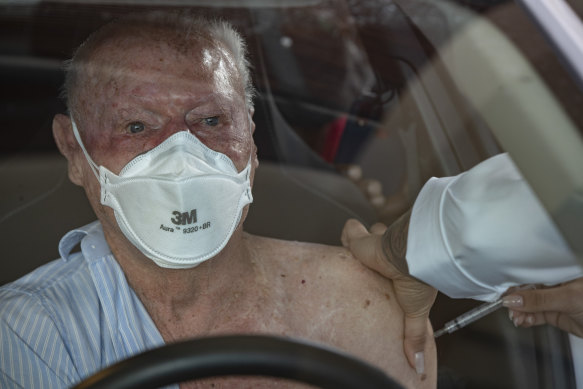 A health worker gives a shot of China’s Sinovac CoronaVac during a priority COVID-19 vaccination program for the elderly at a drive-thru site in Sao Paulo, Brazil.