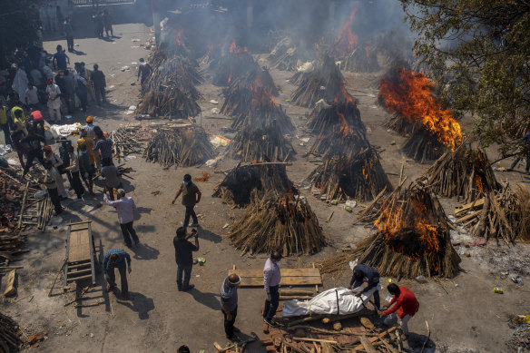 Multiple funeral pyres of victims of COVID-19 burn in an area that has been converted into a crematorium for mass cremation in New Delhi.