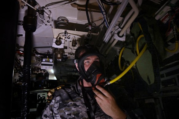 Submariner Lt Wade checks respirators onboard the HMAS Rankin.