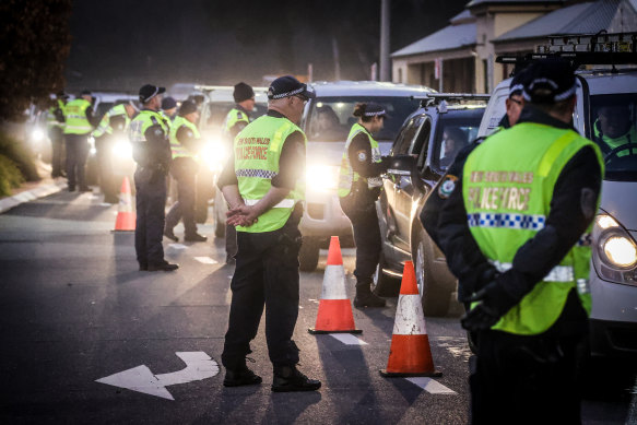 Police stop and question drivers arriving from Victoria at a checkpoint in Albury, NSW. 
