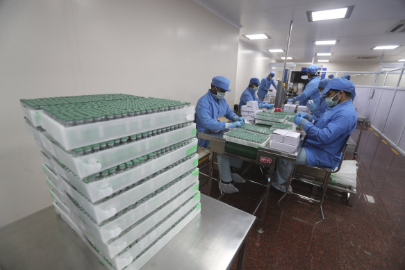 Employees pack boxes containing vials of AstraZeneca’s COVID vaccine at the Serum Institute of India, in Pune.