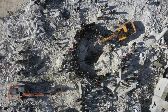 Rescuers and residents search through the rubble of collapsed buildings in the town of Harem near the Turkish border, Idlib province, Syria.