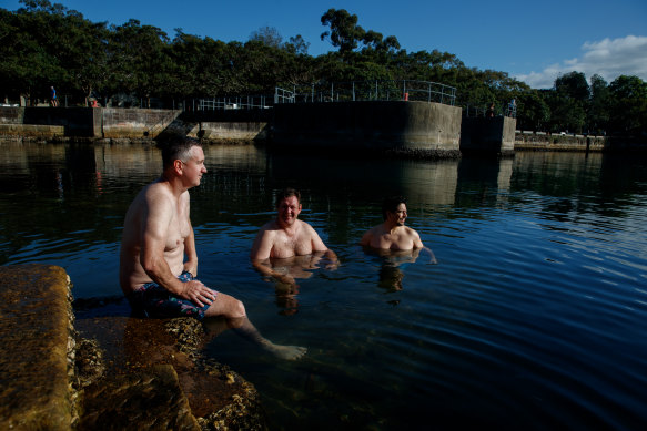Local Rory Steinle-Davis (centre) takes a dip with friends Dominic Curran and Jorge Yanez Stegmaier at Mort Bay on Saturday.
