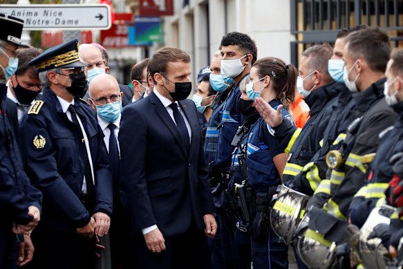 French President Emmanuel Macron meets police and rescue workers outside the cathedral in Nice.