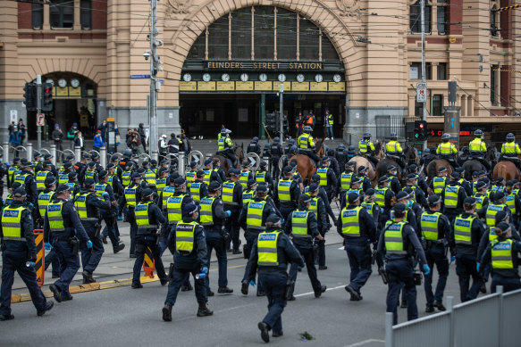 Police officers file past Flinders Street Station on Tuesday afternoon.