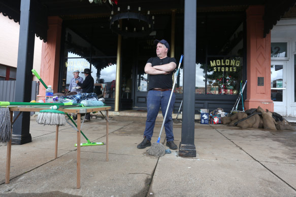 Robert Carroll stands outside his shop in Molong after the flood had subsided.