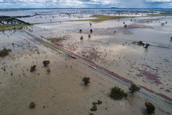 Controlled traffic crawls through widespread floodwaters south-west of Forbes.