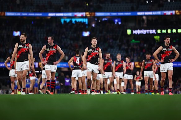 Essendon players trudge off Marvel Stadium after being thrashed by the Western Bulldogs.