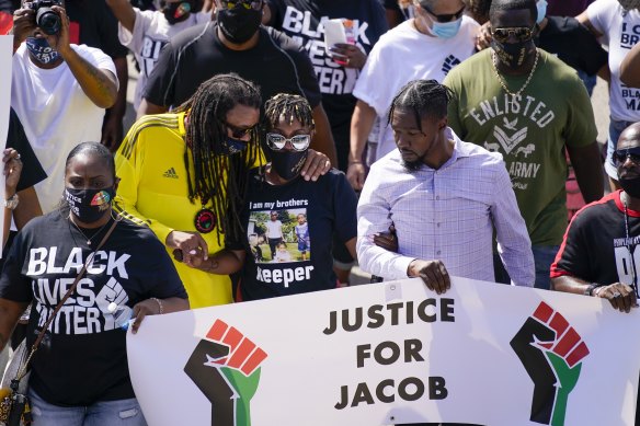 Jacob Blake's sister Letetra Widman (centre) and uncle Justin Blake (left) march at a rally for Jacob Blake on Saturday in Kenosha, Wisconsin. 