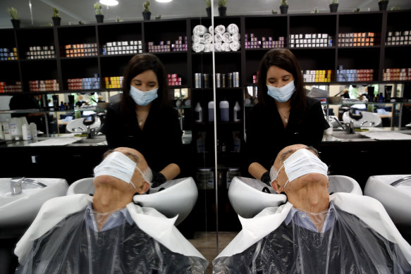 A man gets his hair cut at a salon in Sevres, outside Paris, on Monday.