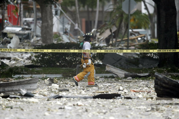 A firefighter walks through the remains of a building after the explosion in Plantation, Florida. 