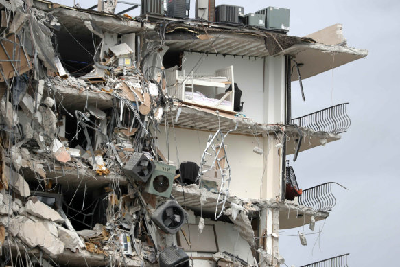 Debris dangles from a section of the collapsed apartment building.