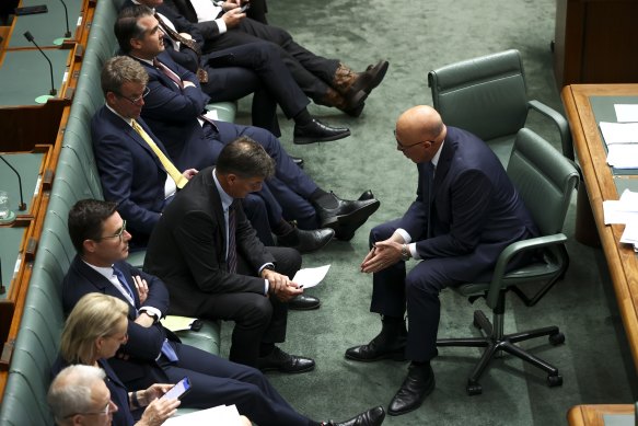 Peter Dutton and his shadow treasurer Angus Taylor talk in Question Time.