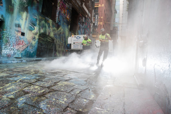 Cleaning in Melbourne's Hosier Lane, where masked people paint-bombed popular street art.