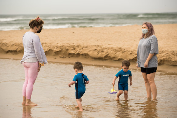 Becc Carroll (right) with a friend and their children at the beach in Torquay. 