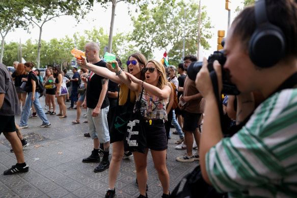 Protesters shoot water from water pistols at tourists during a protest against mass tourism in Barcelona.