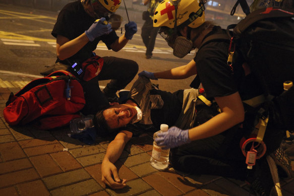 Medical workers help a protester after police fired tear gas in an effort to break up crowds.