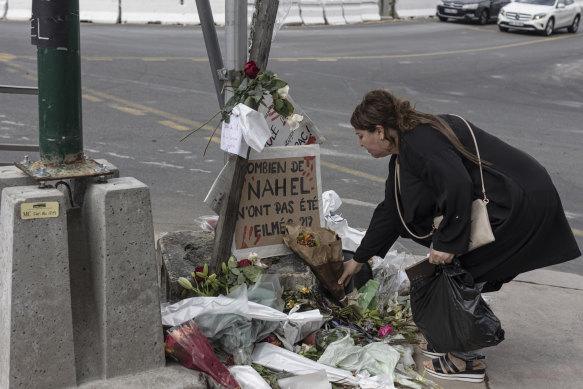 A woman pays her respects at the site where Nahel Merzouk died in Nanterre, France.