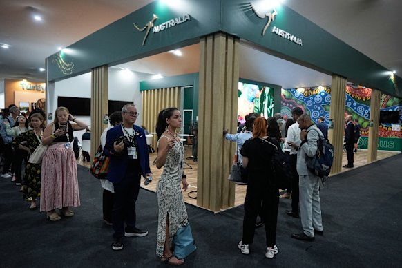 Pessoas fazem fila no Pavilhão Australiano na cúpula climática COP30. O pavilhão turco fica ao lado. 
