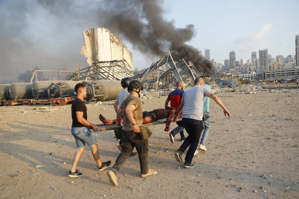 Civilians carry a person at the explosion scene that hit the seaport.