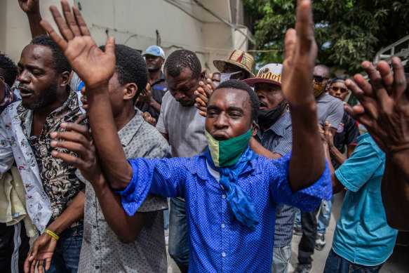 Haitians rally outside a courthouse as prosecutors question senior political figures such as Senate President Youri Latortue and former senator Steven Benoit over the assassination.