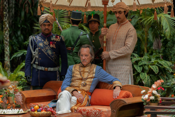 Richard E. Grant (seated) as The Raja. 