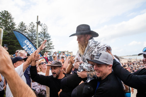 Former pro surfer Blake Johnston leaves the water and is greeted by family and fans.