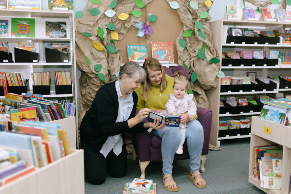 Gilgandra librarian Liz McCutcheon reads to Margeaux Batten and her 11-month-old daughter, Bethany.
