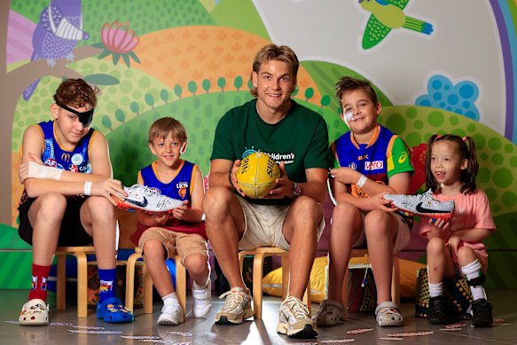 Ashcroft with Cooper Hateley, Taj Juster, Sam Matthews and Malika Toghill at the Queensland Children’s Hospital ahead of the auction of his 2024 grand final boots to raise money for sick children.