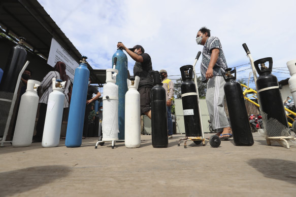 People queue up to refill their oxygen tanks at a filling station in Jakarta