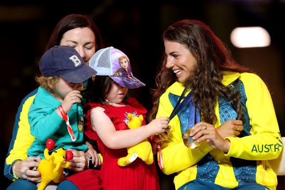 Anna Meares’ children play with Jessica Fox’s medals during the Australian Olympians’ return to Sydney.