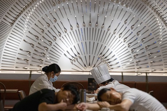 Restaurant workers nap on tables at a restaurant in a shopping centre in Beijing.