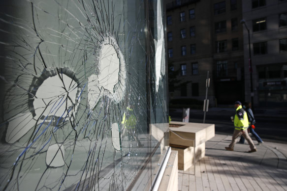 Cleanup workers walk past broken office building windows on Sunday morning in Washington.
