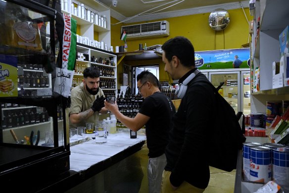 Jalloul serves customers Huey Nguyen (centre) and Yahya Alghamdi (right).