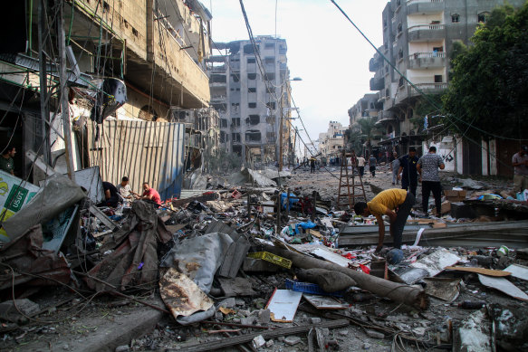 Palestinians inspect damage caused by airstrikes in the Karama area of Gaza City.