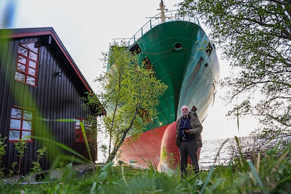 Johan Helberg stands next to his house with its new garden feature – the container vessel NCL Salten.