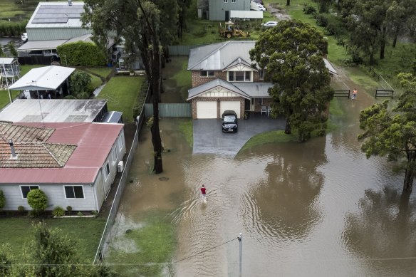 A resident walks to their property as flash flooding impacts properties in Shane’s Park on Monday.