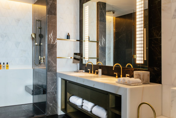 A double vanity, standalone bath and walk-in shower feature in the bathroom of a deluxe king room.