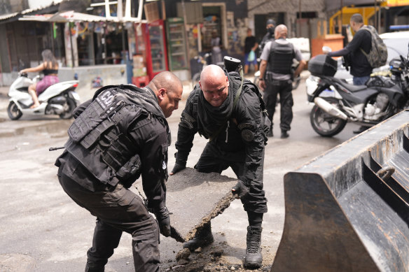 Police clear a street barricade illegally installed at the Mare Complex neighbourhood in Rio on October 9.