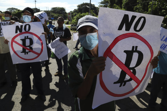 Farmers hold signs emblazoned with messages against the country adopting bitcoin as legal tender in San Vicente, El Salvador.