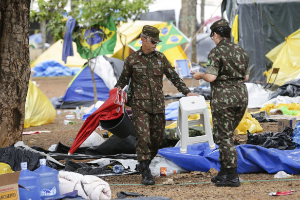 Askerler, Bolsonaro destekçileri tarafından kurulan bir kampın temizlenmesine yardım ediyor.