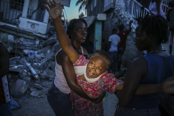 Oxiliene Morency cries out in grief after the body of her 7-year-old-daughter Esther Daniel was recovered from the rubble of their home destroyed by the earthquake in Les Cayes, Haiti.