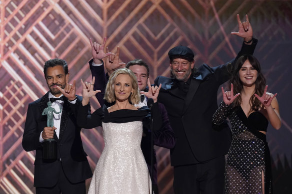 The cast of CODA accepts the award for outstanding performance by a cast in a motion picture and signs “I love you” at the SAG Awards.