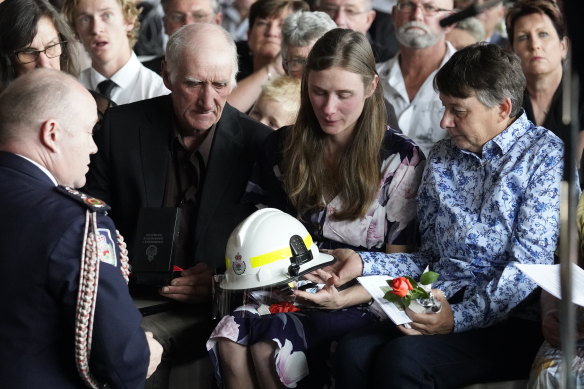 RFS Commissioner Shane Fitzsimmons presents Samuel McPaul's helmet to his widow, Megan, during his funeral.