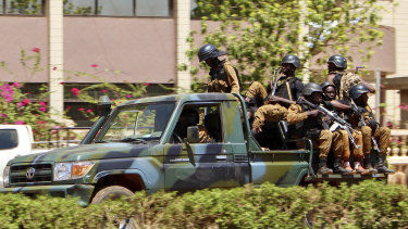 Troops ride in a vehicle near the French Embassy in Burkina Faso after gunfire and explosions rocked the capital. 