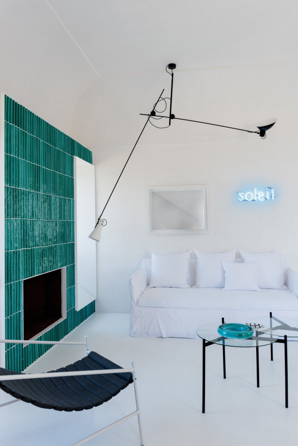 In the living area, the fireplace reflects the island’s 1950s tradition of
using ceramic tiles in copper-green. The “Ghost” sofa is by Gervasoni.