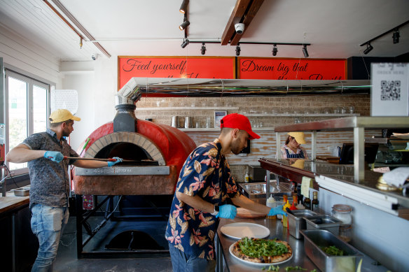 Pizzaiolos work the oven at Fratelli Pulcinella in Parramatta.